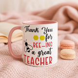 Mug with 'Thank you for bee-ing a great teacher' text on a pink background