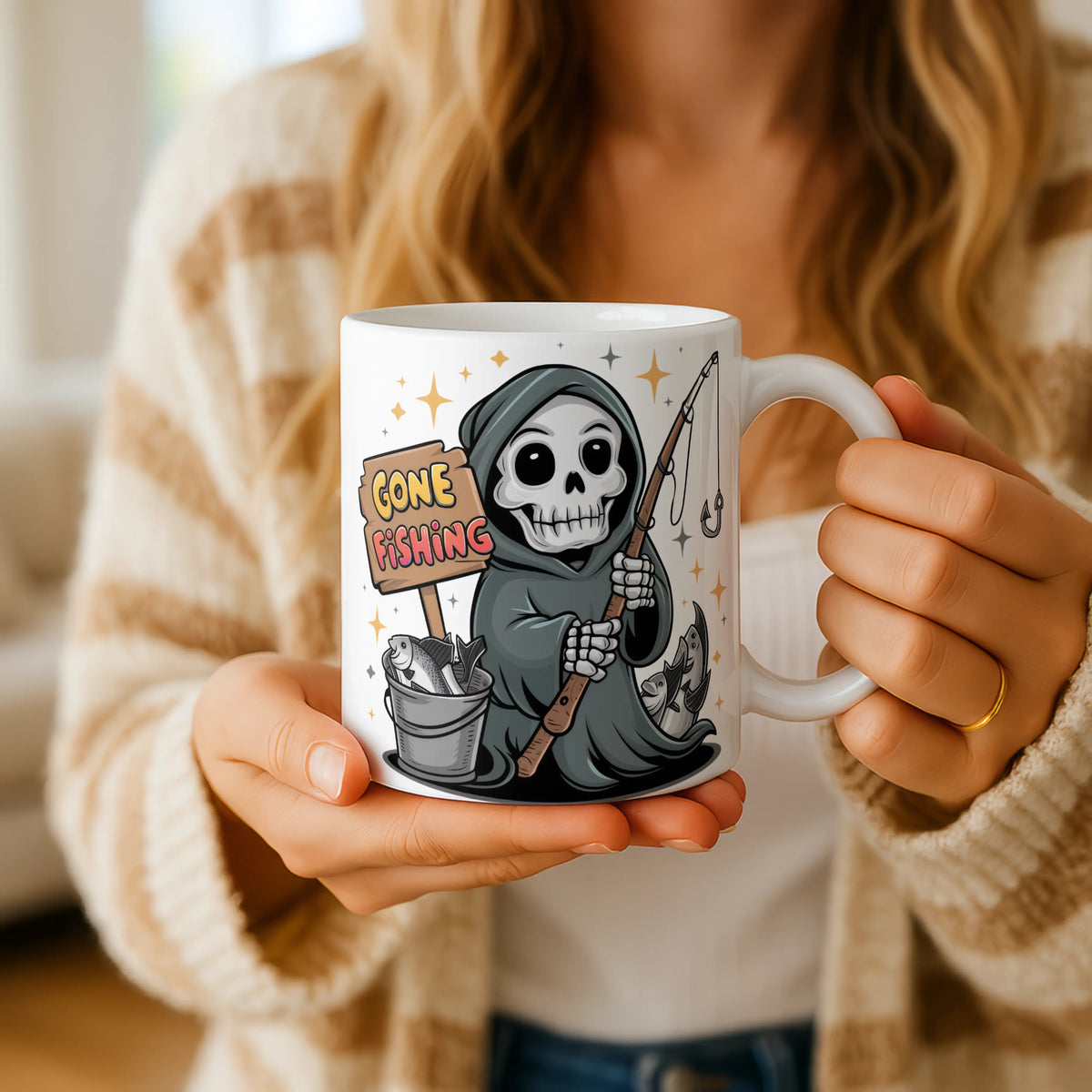 Person holding a mug with a skeleton design and 'Gone Fishing' text.